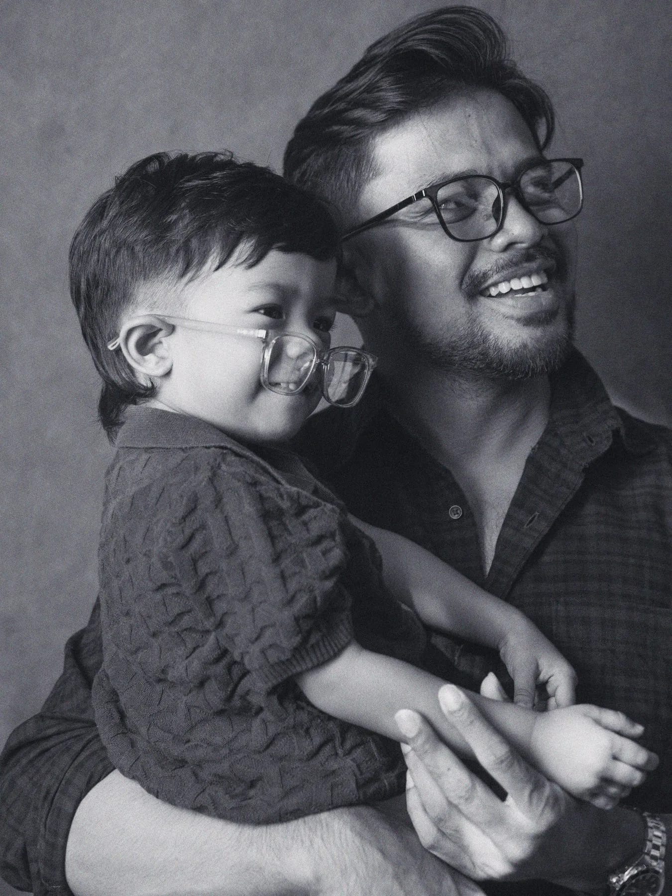 A father and son trying on glasses together